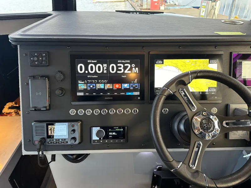 Slide: The Image of 2023 Life Proof 35 Full Cabin boat dashboard with navigation screens and steering wheel. - 6