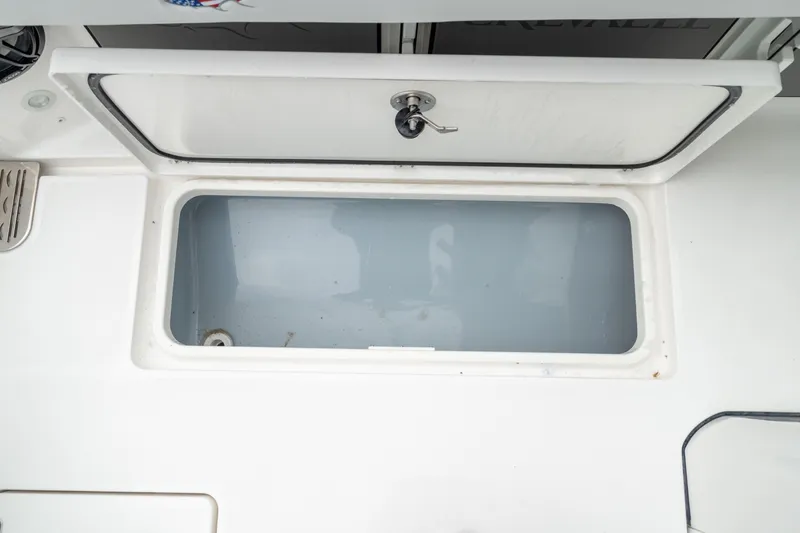 Slide: The Image of Livewell compartment on 2026 Crevalle 33 CSF boat, featuring a secure latch. - 16