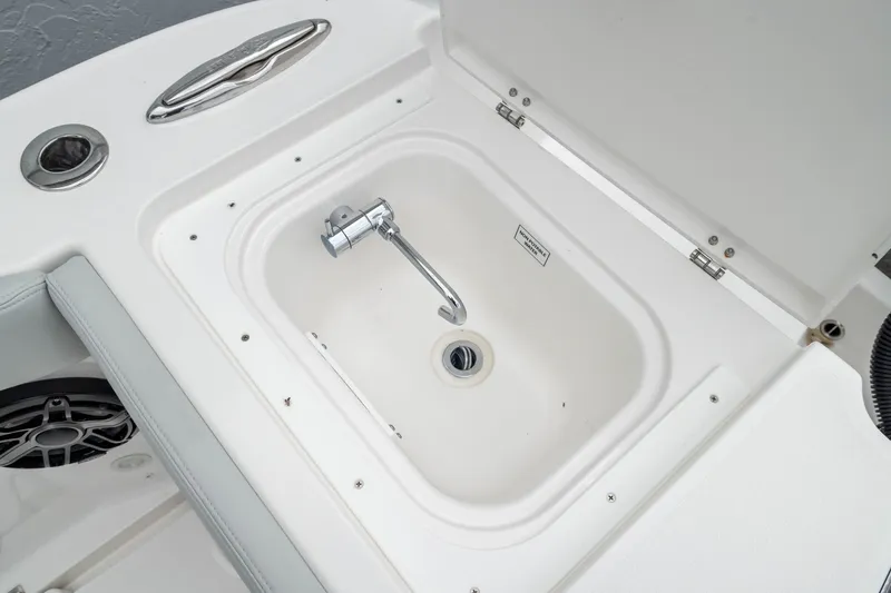 Slide: The Image of Livewell compartment on 2026 Crevalle 33 CSF boat, featuring a faucet and drain. - 22