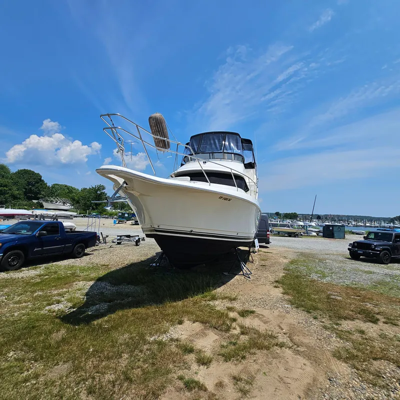 Slide: The Image of 2000 Silverton 392 Motor Yacht on land, clear sky, parked vehicles nearby. - 2