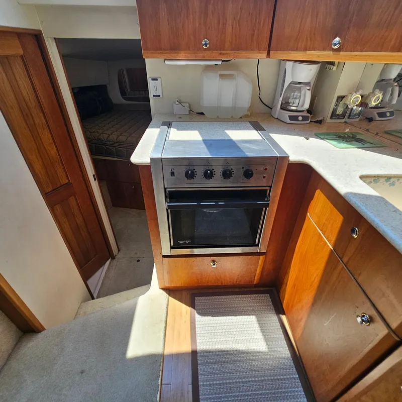 Slide: The Image of 2000 Silverton 392 Motor Yacht kitchen with oven, coffee maker, and wooden cabinetry. - 26