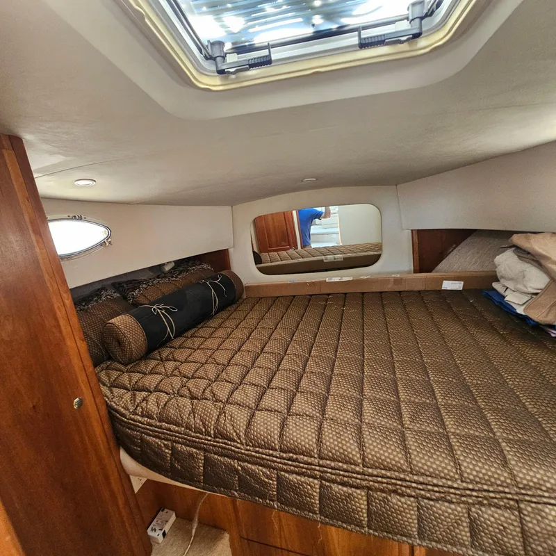 Slide: The Image of Cozy cabin interior of 2000 Silverton 392 Motor Yacht with quilted bedding and porthole window. - 29