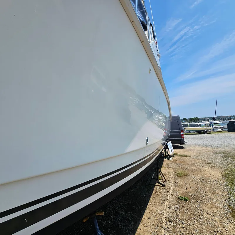 Slide: The Image of Side view of a 2000 Silverton 392 Motor Yacht on dry land under a clear sky. - 5