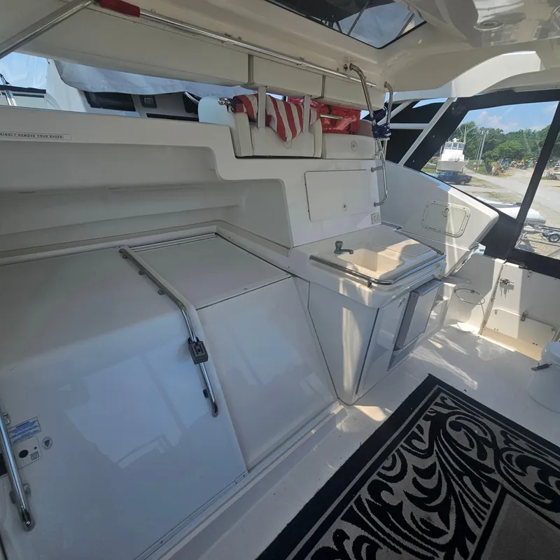 Slide: The Image of 2000 Silverton 392 Motor Yacht interior with kitchenette and storage, featuring sleek white design. - 8