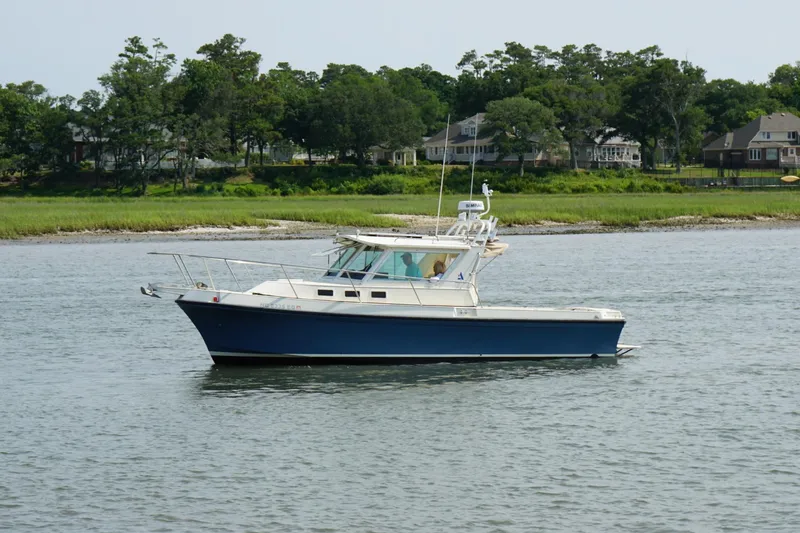 Slide: The Image of 1996 Albin 28TE boat cruising on a calm river with lush green shoreline. - 3