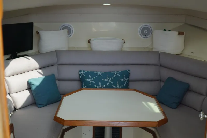Slide: The Image of 1996 Albin 28TE boat interior with cushioned seating and decorative pillows. - 5