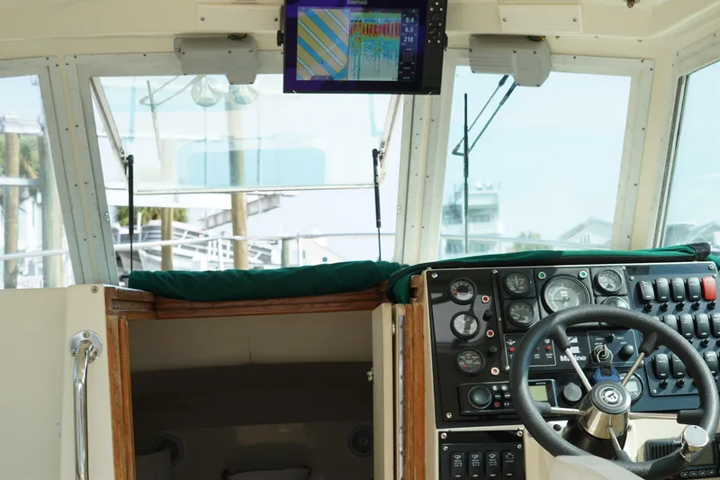 Slide: The Image of 1996 Albin 28TE boat cockpit with steering wheel, control panel, and navigation screen. - 8