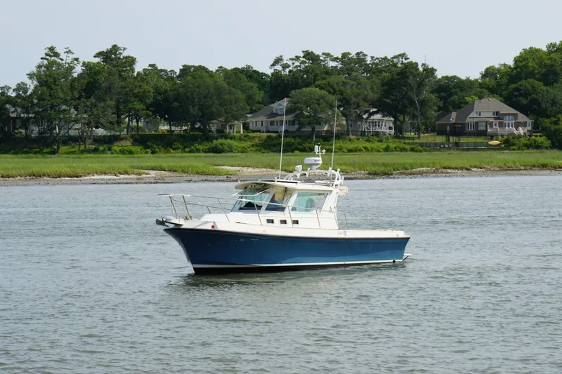 Slide: The Image of 1996 Albin 28TE boat cruising on a calm river with lush green shoreline. - 9