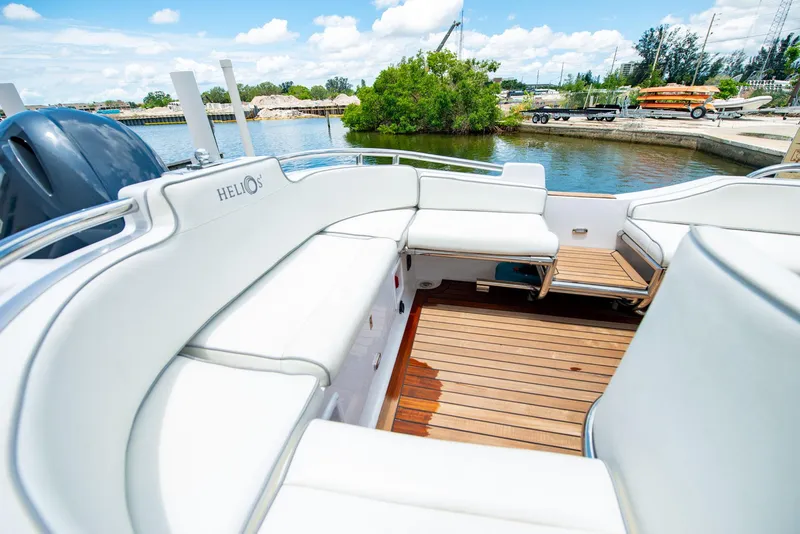 Slide: The Image of 2006 Novurania RHIB boat with white seating and wooden deck, docked by a scenic waterfront. - 11