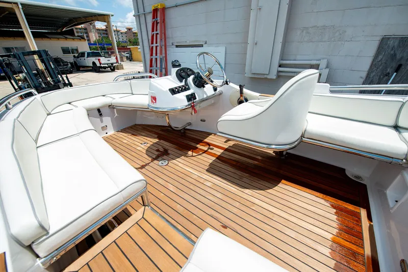 Slide: The Image of 2006 Novurania RHIB boat interior with white seating and wooden deck. - 15