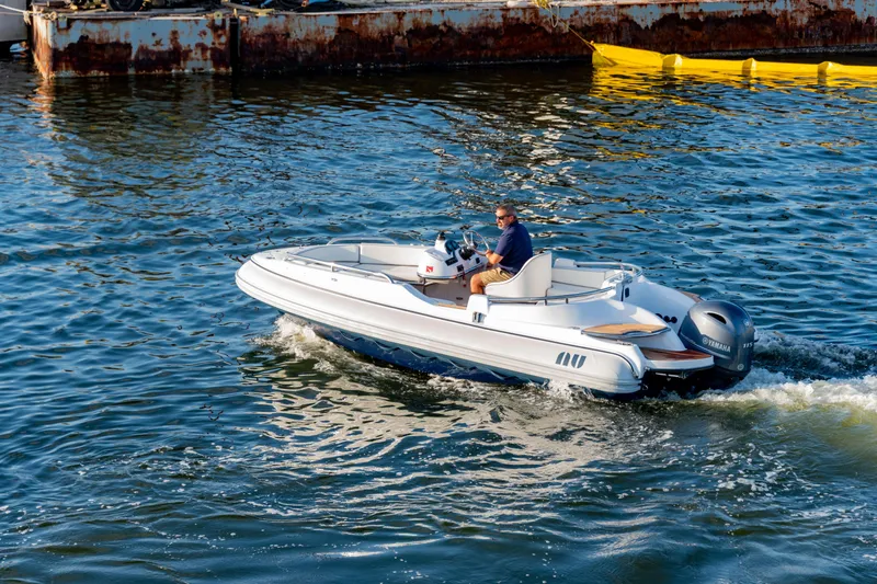 Slide: The Image of 2006 Novurania RHIB boat with Yamaha engine cruising on water. - 2
