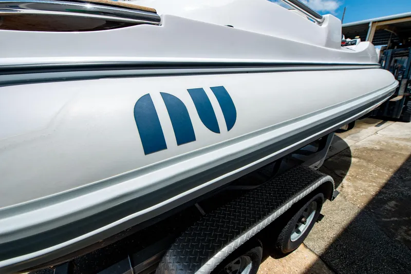 Slide: The Image of 2006 Novurania RHIB boat on trailer, side view with logo visible. - 20