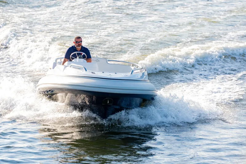 Slide: The Image of 2006 Novurania RHIB boat navigating through waves with a person steering. - 4