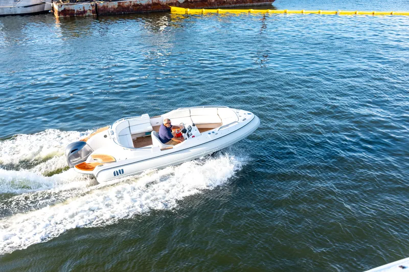 Slide: The Image of 2006 Novurania RHIB boat cruising on water with a person steering. - 6