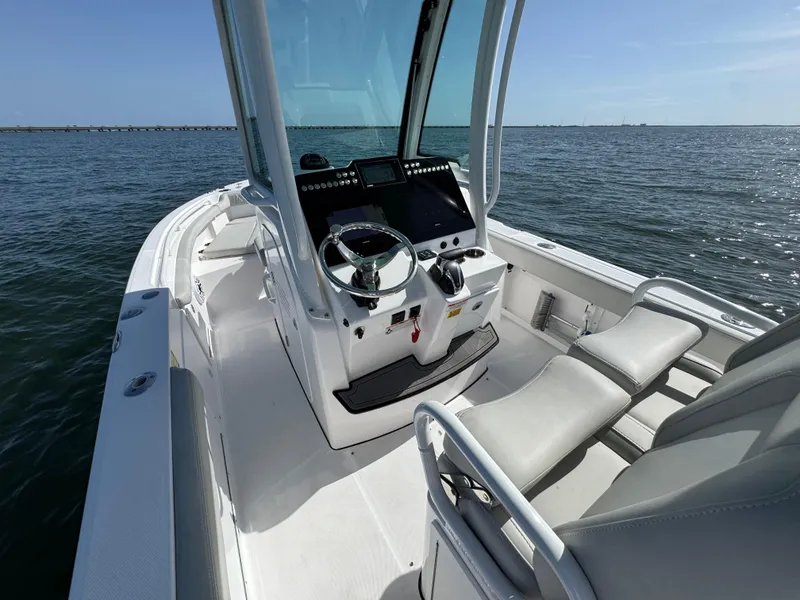 Slide: The Image of 2022 Everglades 235 Center Console boat on open water, featuring modern helm and seating. - 17