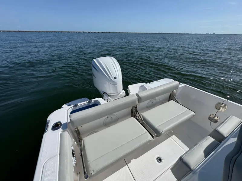 Slide: The Image of 2022 Everglades 235 Center Console boat on calm water, featuring comfortable seating and outboard motor. - 21