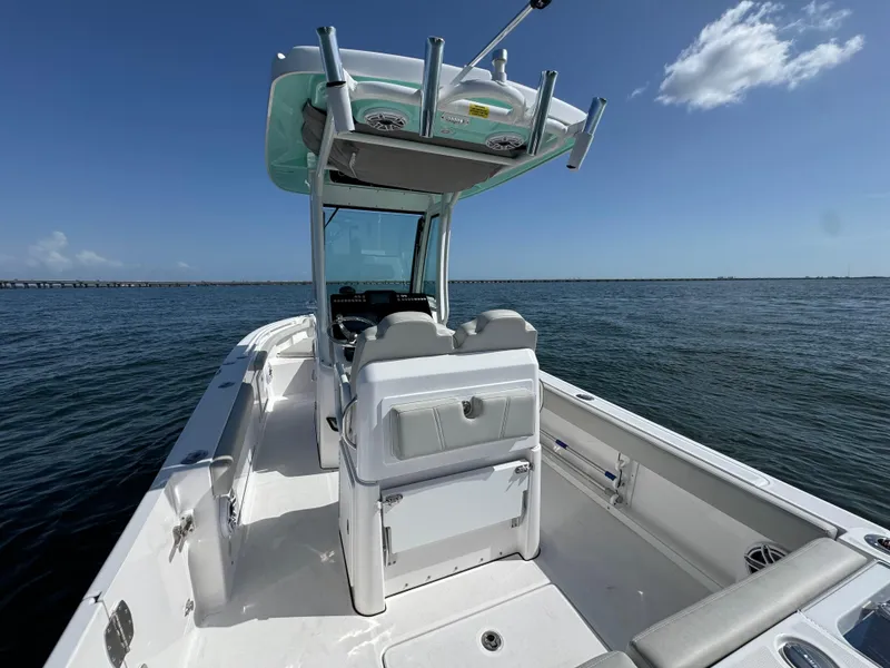 Slide: The Image of 2022 Everglades 235 Center Console boat on open water under clear blue sky. - 24