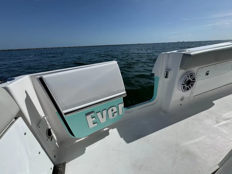 Slide: The Image of 2022 Everglades 235 Center Console boat on open water, featuring sleek design and spacious deck. - 26