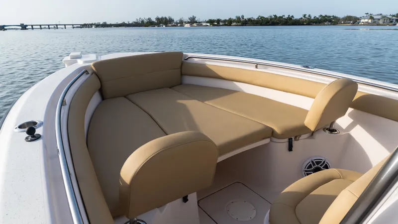 Slide: The Image of Grady-White 273 Chase CC 2025 boat interior with tan seating, on calm water. - 10