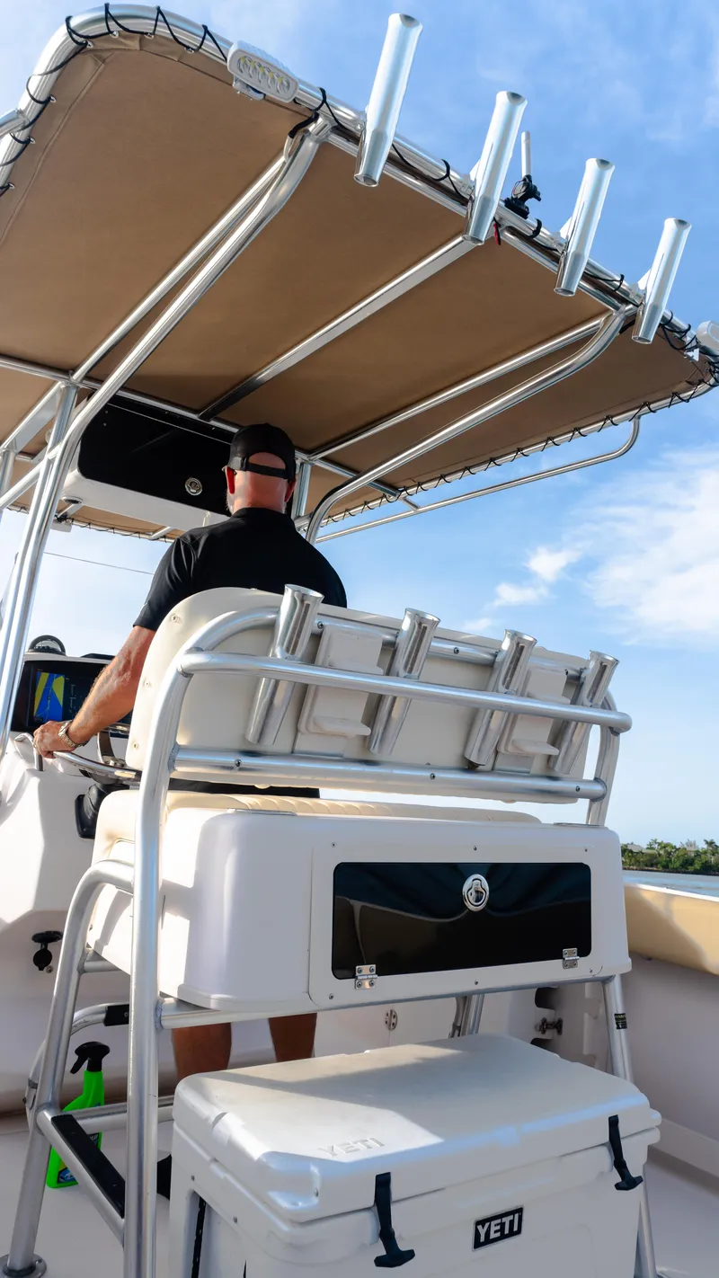 Slide: The Image of Man steering Grady-White 273 Chase CC 2025 boat under clear blue sky. - 13
