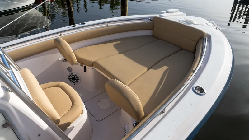 Slide: The Image of Grady-White 273 Chase CC 2025 boat interior with tan seating, docked by water. - 2