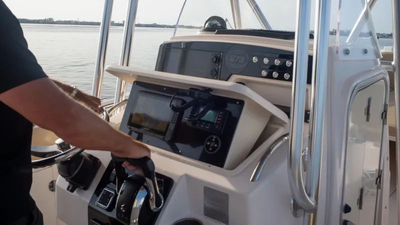 Slide: The Image of Grady-White 273 Chase CC 2025 boat console with navigation equipment on calm water. - 4