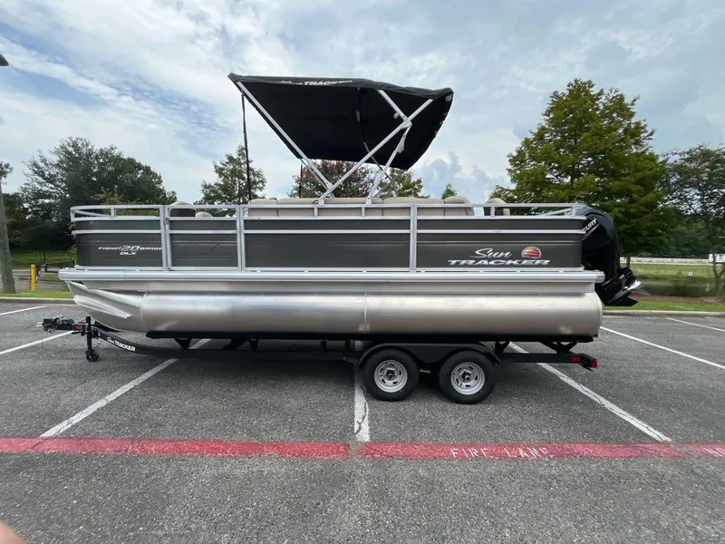 The Image of 2025 Sun Tracker Fishin' Barge 20 DLX pontoon boat parked in a lot. - 0