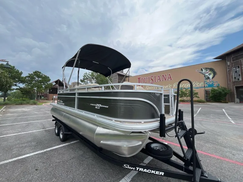 Slide: The Image of 2025 Sun Tracker Fishin' Barge 20 DLX pontoon boat in parking lot, overcast sky. - 3