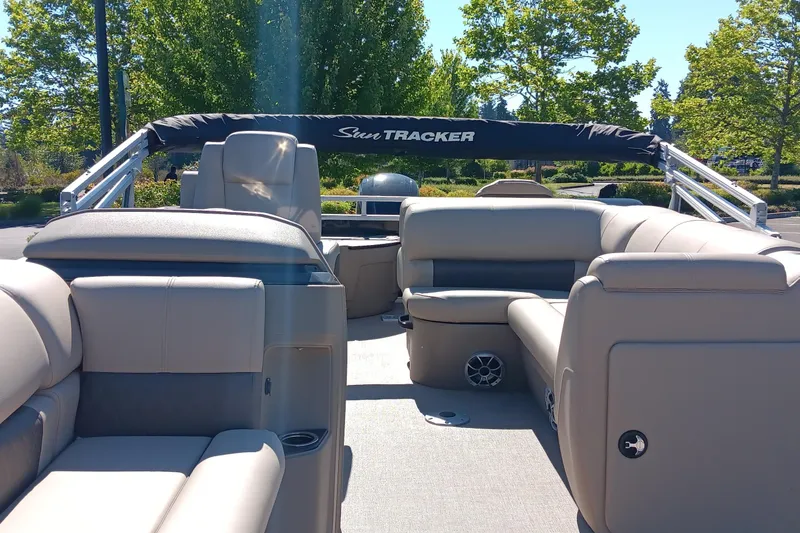 Slide: The Image of 2025 Sun Tracker SportFish 20 DLX pontoon boat interior with beige seating and canopy. - 4