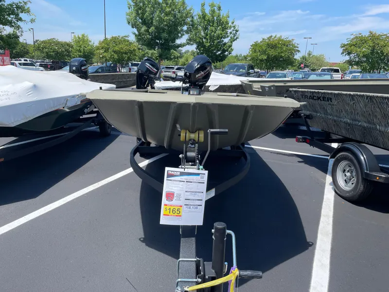 Slide: The Image of 2025 Tracker Grizzly 1654 T Sportsman boat displayed in a parking lot. - 2
