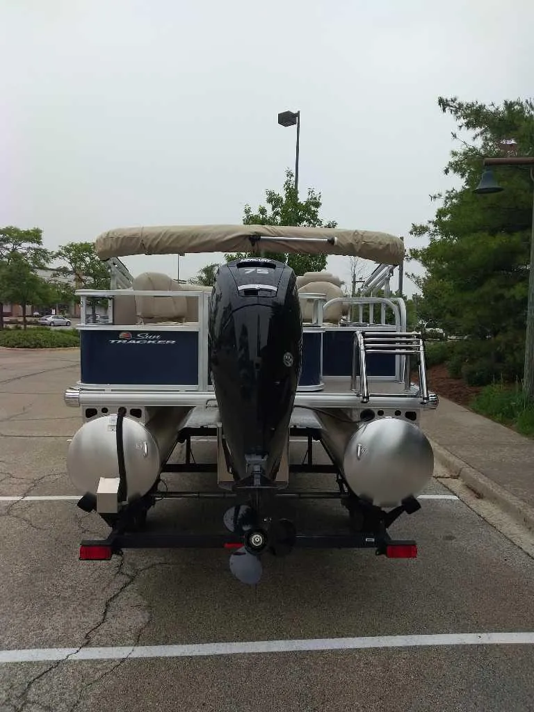 Slide: The Image of 2025 Sun Tracker Bass Buggy 18 DLX pontoon boat, rear view in parking lot. - 6
