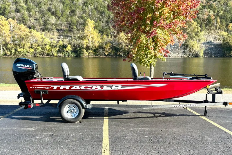 The Image of 2025 Tracker Panfish 17 boat, red, parked by a scenic lake with autumn trees. - 0