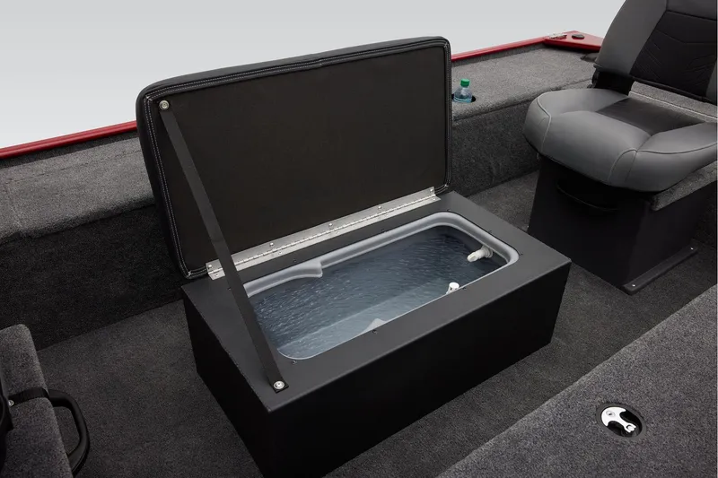 Slide: The Image of Open storage compartment on 2025 Tracker Panfish 17 boat, featuring gray interior and carpeted flooring. - 17