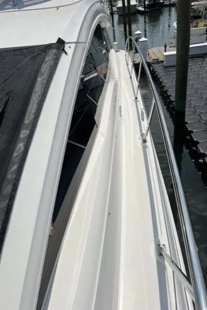 Slide: The Image of 2016 Sea Ray 510 Fly yacht docked, showcasing sleek side deck and railing. - 19