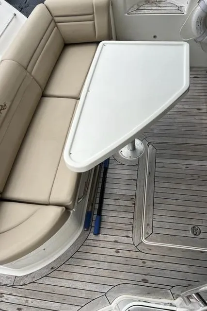 Slide: The Image of 2016 Sea Ray 510 Fly yacht interior with beige seating and white table on wooden deck. - 20