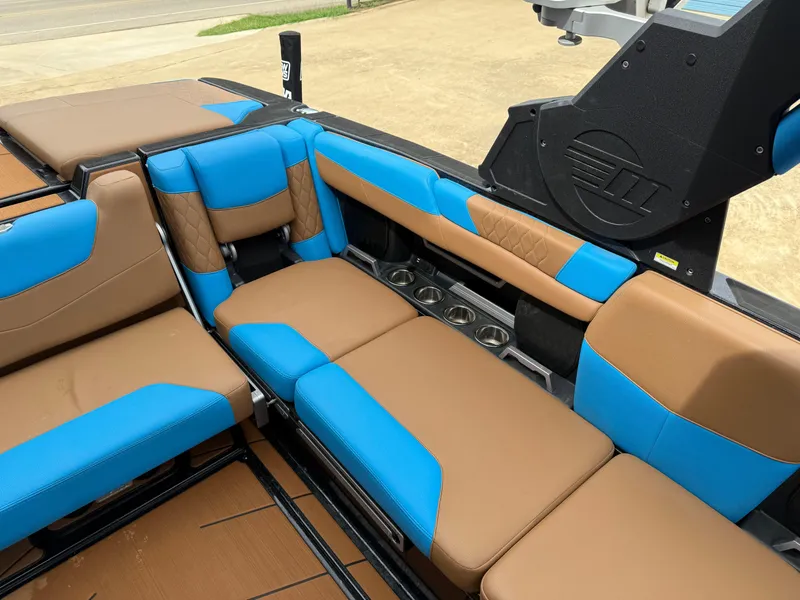Slide: The Image of 2021 Malibu M240 boat interior with blue and brown seating, showcasing luxury and comfort. - 10