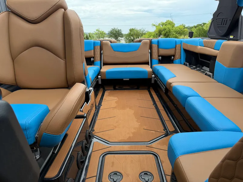 Slide: The Image of Interior of a 2021 Malibu M240 boat with brown and blue seating. - 5