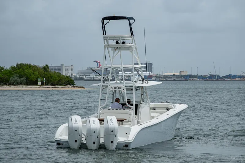 Slide: The Image of 2013 Yellowfin 39 Offshore boat with triple engines cruising on a calm waterway. - 11
