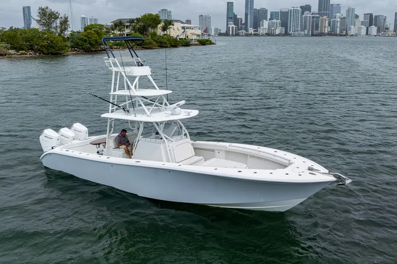 Slide: The Image of 2013 Yellowfin 39 Offshore boat on water with city skyline in background. - 15