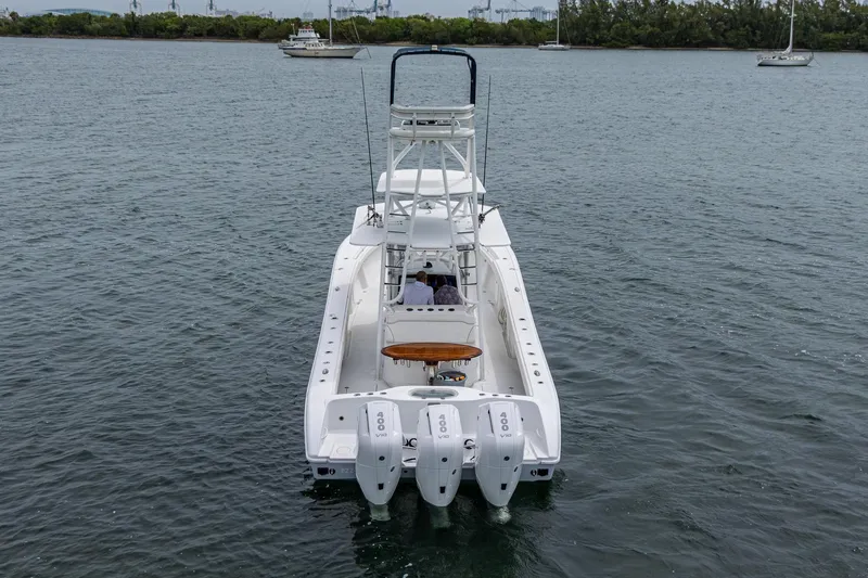 Slide: The Image of 2013 Yellowfin 39 Offshore boat with triple outboard engines on calm water. - 22