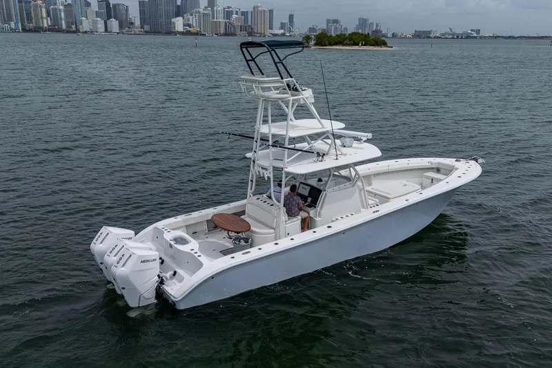 Slide: The Image of 2013 Yellowfin 39 Offshore boat on water with city skyline in background. - 24