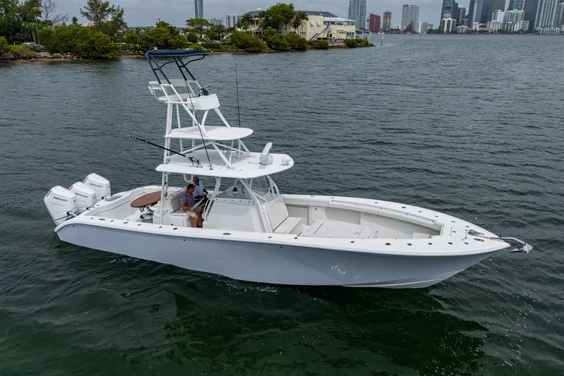 Slide: The Image of 2013 Yellowfin 39 Offshore boat on water, featuring triple outboard engines. - 25