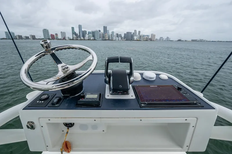 Slide: The Image of Helm of 2013 Yellowfin 39 Offshore boat with city skyline in background. - 27