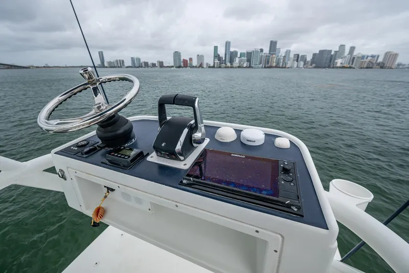 Slide: The Image of 2013 Yellowfin 39 Offshore boat helm with city skyline in background. - 28