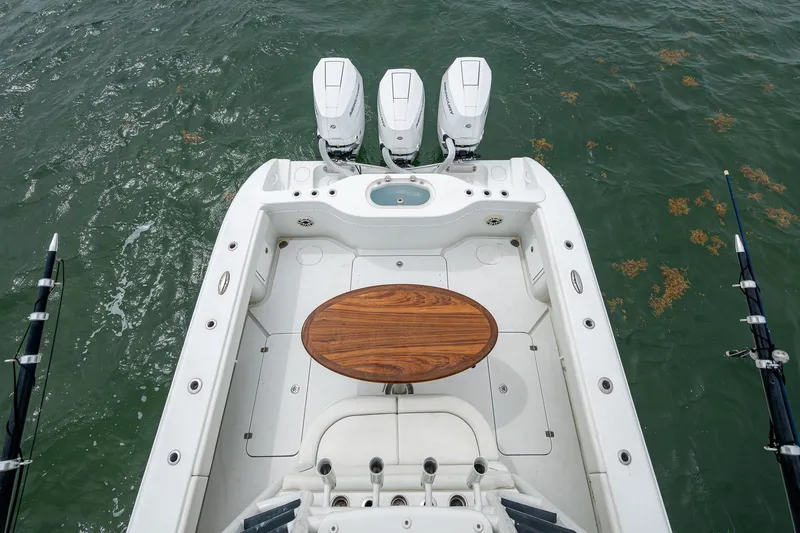 Slide: The Image of 2013 Yellowfin 39 Offshore boat with triple engines and wooden table on deck. - 29