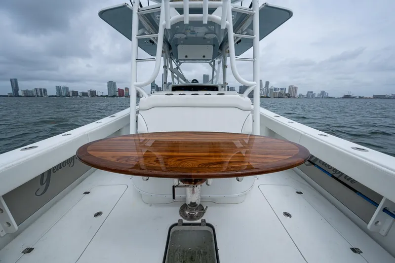 Slide: The Image of 2013 Yellowfin 39 Offshore boat with wooden table, city skyline in background. - 34