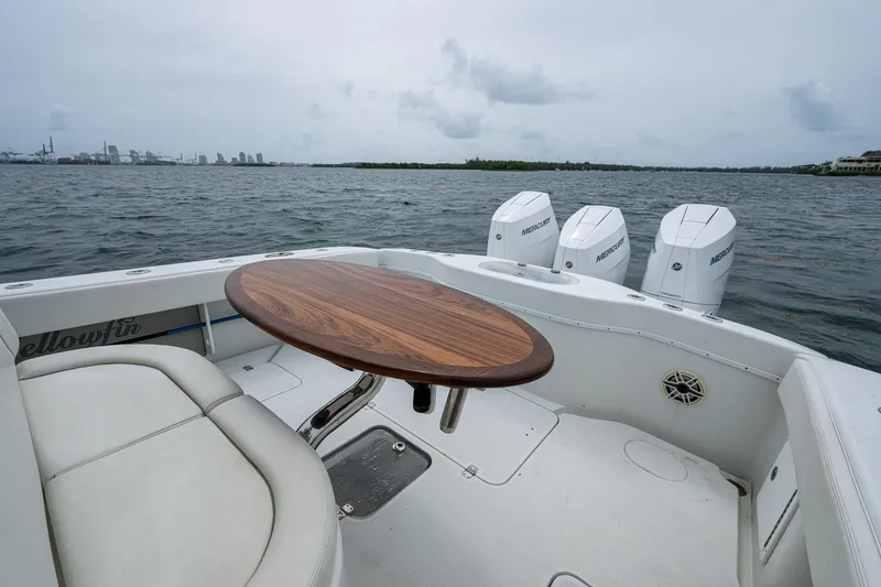 Slide: The Image of 2013 Yellowfin 39 Offshore boat with triple outboard engines and a wooden table on deck. - 35