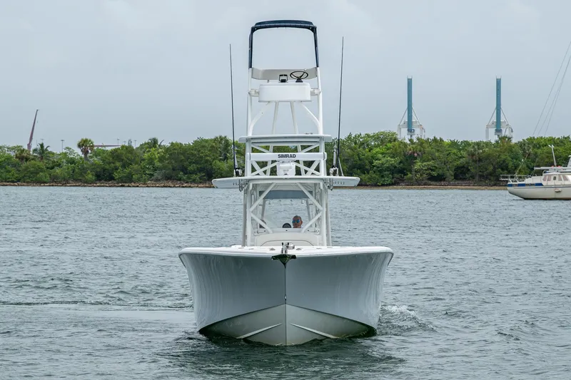 Slide: The Image of 2013 Yellowfin 39 Offshore boat on water, front view, with lush greenery in background. - 4