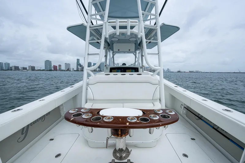Slide: The Image of 2013 Yellowfin 39 Offshore boat interior with rod holders, city skyline in background. - 40