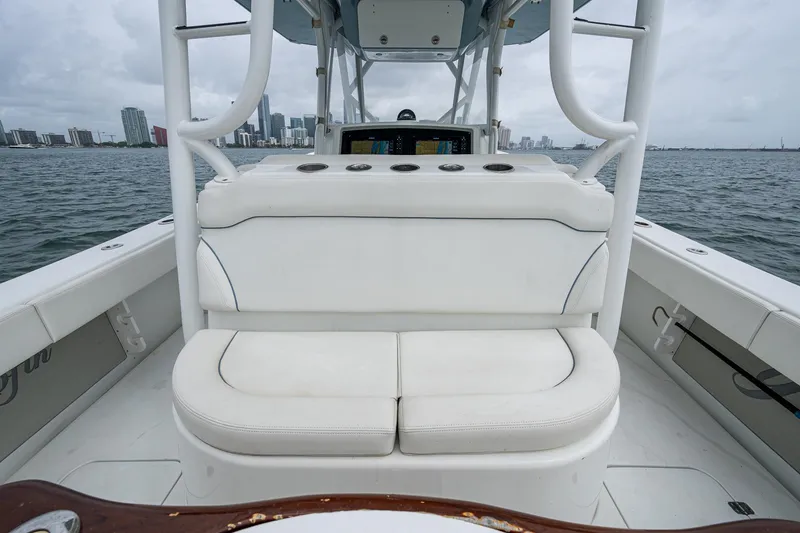 Slide: The Image of 2013 Yellowfin 39 Offshore boat interior with white seating, ocean view, and city skyline. - 42